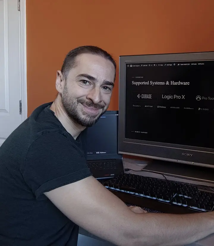 Paul Andrews working at his desk at Audio Support, hand on the mouse, the Audio Support site open on screen